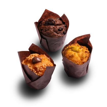 Three muffins in brown paper wrappers: chocolate chip, caramel with a chocolate piece, and pistachio-topped, on a whi...