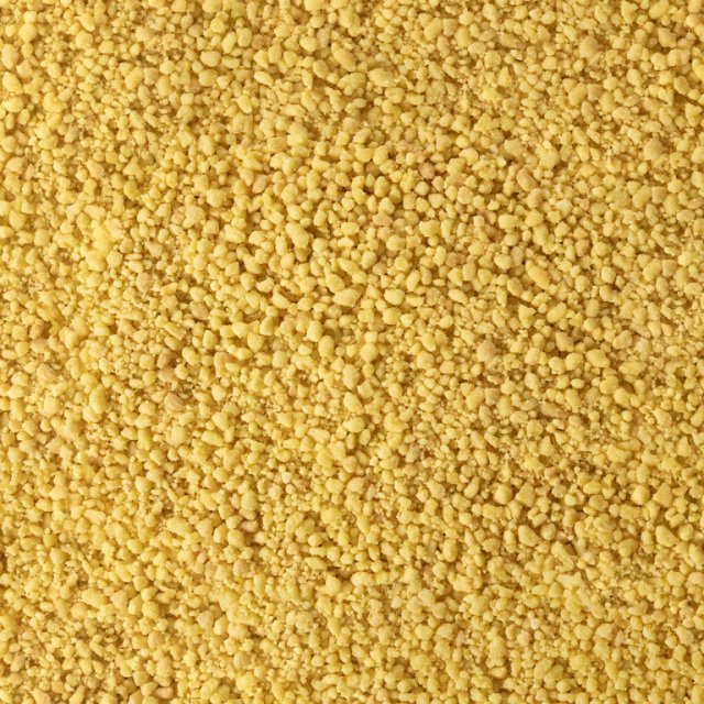 Close-up of fine yellow granular texture, resembling coarse cornmeal or dried couscous grains covering the entire frame.