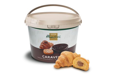 Beige bucket of Master Martini Caravel chocolate spreadable cream beside two croissants, one filled with chocolate.
