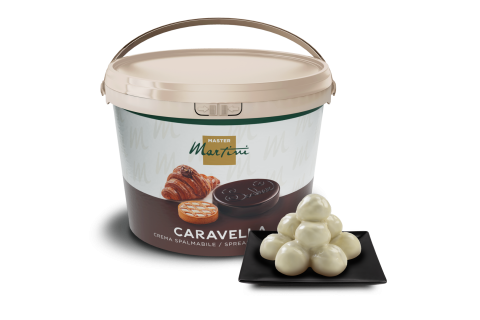 A large tub of Master Martini Caravella spreadable cream beside white chocolate truffles on a black square plate.