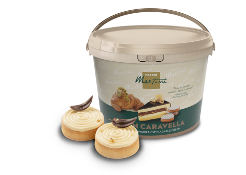 Large tub of Master Martini spreadable cream beside two frosted pastries topped with chocolate curls and gold flecks.