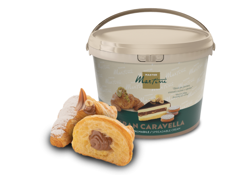 A large bucket of Master Martini Gran Caravella spreadable cream beside two cream-filled pastries dusted with powdere...
