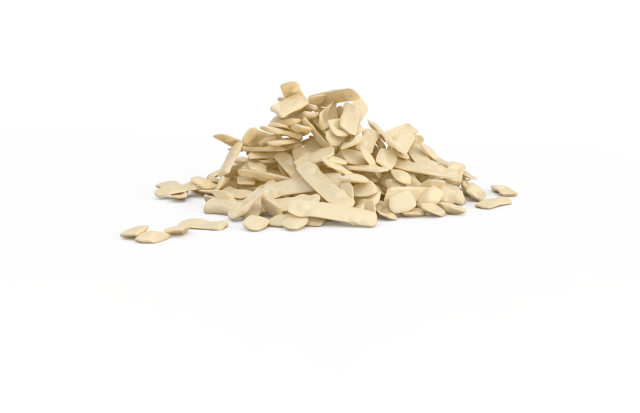A pile of irregularly shaped beige plastic or wax flakes on a plain white background.