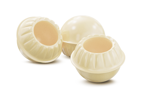 Three round white chocolate shells with fluted rims, two hollowed out, on a white background.