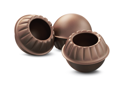 Three empty round chocolate shells with fluted, scalloped rims and hollow centers, arranged on a white background.