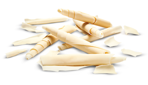Curled white chocolate shavings and scroll-shaped pieces scattered on a white background.