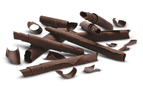 Curled dark chocolate shavings of various sizes scattered on a white background.